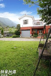 a house with a grass yard in front of it at Dongguang Zhixing Homestay in Yuchi