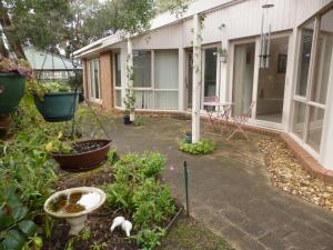 a garden with plants and a patio with a building at Rye Coastal Getaway in Rye