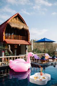 uma piscina com dois cisnes cor-de-rosa na água em Sentulan Garden em Nusa Penida