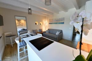 eine Küche und ein Wohnzimmer mit weißer Arbeitsplatte in der Unterkunft TiAMo Modern Design Guest House in Ronchi dei Legionari