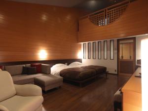 1 dormitorio con 1 cama y 1 sofá en Jozankei Tsuruga Resort Spa Mori no Uta en Jozankei