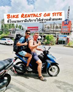 two men sitting on a motorcycle in the street at Lemonade Phuket Hotel -SHA Plus in Chalong