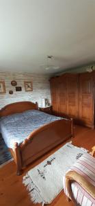 1 dormitorio con cama de madera y armarios de madera en Les Lupins, en Geishouse