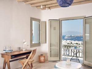 a room with a desk and a view of the ocean at Belvedere Mykonos - Hilltop Rooms & Suites - The Leading Hotels of the World in Mikonos