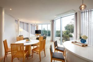 une salle à manger et un salon avec une table et des chaises dans l'établissement Lotte Resort Jeju Artvillas, à Seogwipo
