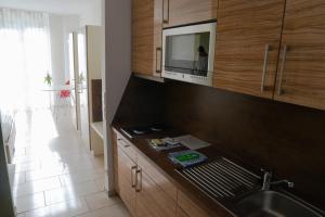 eine Küche mit einer Spüle und einer Mikrowelle in der Unterkunft first Apart in Erlangen
