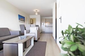 a living room with a couch and a table at Evancy Villa les Margats in Bray-Dunes