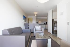 a living room with a couch and a table at Evancy Villa les Margats in Bray-Dunes