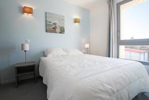 ブレ・デューンにあるEvancy Villa les Margatsのベッドルーム(大きな白いベッド1台、窓付)