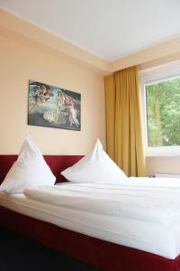a hotel room with two beds and a window at Wiking Hotel in Henstedt-Ulzburg