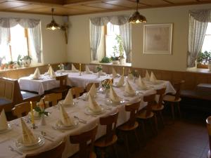 a dining room with tables and chairs with white tablecloths at Hotel-Gasthof Krone in Greding