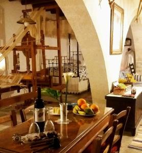 - une table avec une assiette de fruits et une bouteille de vin dans l'établissement Aliki's House 1+ 2, à Pólis Chrysochoús