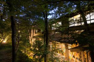 un edificio en medio de un bosque por la noche en Ryokan Wakaba, en Minamioguni