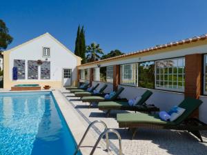 a row of chaise lounge chairs next to a swimming pool at Vida-Vi, Country House and B&B in Santa Catarina