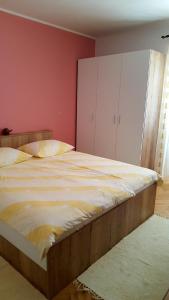 a large bed in a bedroom with pink walls at Guesthouse Matušan's place in Rab