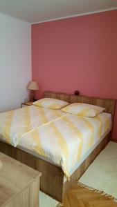 a bedroom with a large bed with yellow and white sheets at Guesthouse Matušan's place in Rab