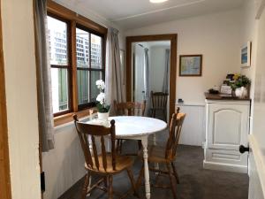 - une cuisine avec une table et des chaises dans la chambre dans l'établissement Recreation Cottage, à Kingston Beach