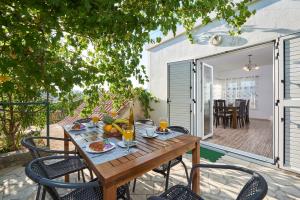 a wooden table with food and drinks on a patio at Apartment Ugrina in Trogir