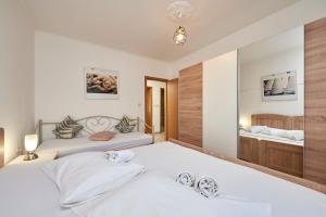 a bedroom with two beds and a mirror at Apartment Ugrina in Trogir