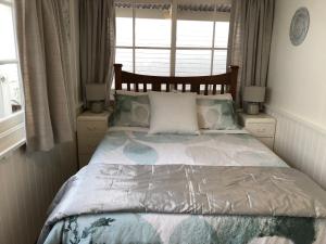 a bedroom with a large bed with a window at Recreation Cottage in Kingston Beach