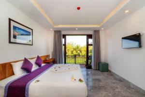 1 dormitorio con 1 cama grande y balcón en Lama Villa Hoi An, en Hoi An