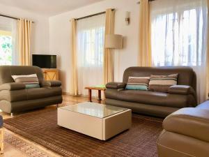 a living room with two couches and a coffee table at Le Palmier - 4 bedrooms BeachFront villa - Gated Complex in Flic-en-Flac