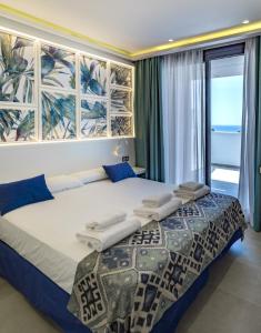 a bedroom with a large bed with a large window at Hotel Playa de la Plata in Zahara de los Atunes