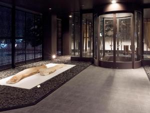a bath room with a large tub and a large mirror at Jozankei Tsuruga Resort Spa Mori no Uta in Jozankei