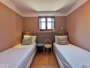 Cette petite chambre comprend deux lits et une table. dans l'établissement Anaroussa Diros Apartment, à Areópoli