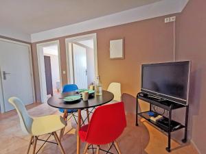 a living room with a table and a tv and chairs at Anaroussa Diros Apartment in Areopolis