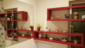 a room with red shelves with vases and plants at Ukiha Kojio no Akari in Ukiha