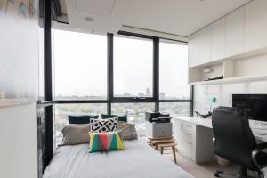 una camera con scrivania e letto e una scrivania di Laurent Balcony Views Steps from Laneway Vibes a Melbourne