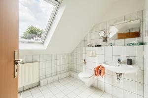 a bathroom with a sink toilet and a window at Ferienwohnungen "Am Waidweg" in Bad Langensalza +62 photos