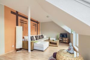 a living room with a white couch and a tv at Ferienwohnungen "Am Waidweg" in Bad Langensalza