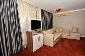 a living room filled with furniture and a tv at Gurkent Hotel in Ankara