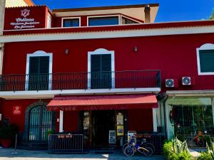 um edifício vermelho com uma varanda e uma bicicleta estacionada em frente em Chateau Les Jumeaux em Pompeia