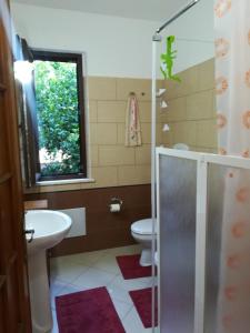 baño con lavabo y aseo y ventana en B&B Zia Delia en Villaperuccio