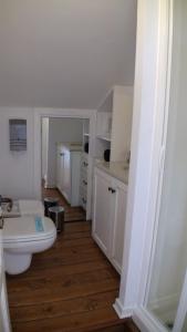 a white bathroom with a toilet and a sink at Locanda Colle Cerqueto in Fiumata