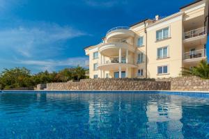 un hotel con piscina frente a un edificio en Luxury Apartments Villa Tunera, en Porat