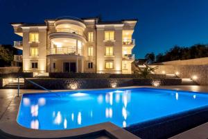 una casa con piscina di fronte a un edificio di Luxury Apartments Villa Tunera a Porat