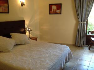 um quarto com uma cama, uma mesa e uma janela em Hostal Cerezo 2 em Guadalupe