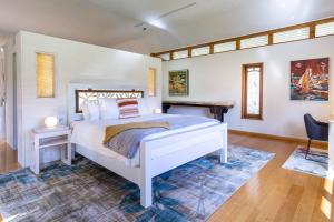 a bedroom with a white bed and a fireplace at Garden Pavilion - Art House Yallingup in Yallingup