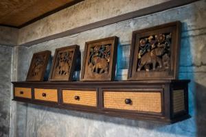 une étagère avec quatre photos sur un mur dans l'établissement Hot Coffee Guest House and Resort, à Ban Mae Na Chon