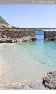 un ponte sull'acqua accanto a una spiaggia di Villa Diana a Capoliveri