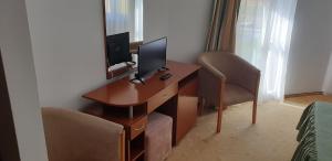 Zimmer mit einem Schreibtisch, einem Computer und einem Stuhl in der Unterkunft HELIOS in Ocna Sibiului
