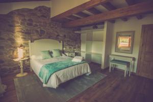 a bedroom with a large bed and a table at Palomba Rural in Espinilla