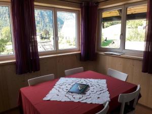 a table with a book on it in a room with windows at Apartment Sandra in Obertraun