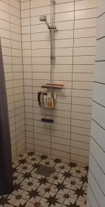 a bathroom with a shower and a tiled floor at B&B Olsegården in Tvååker