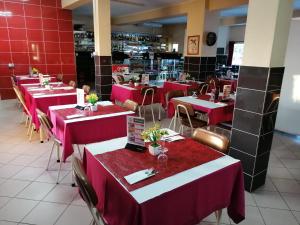 ヴィゼウにあるHospedaria D. Fernandoの赤と白のテーブルと椅子が備わるレストラン
