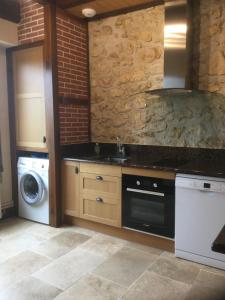 Hastinguesにあるgîte porte de la bastideのシンクと洗濯機付きのキッチン +16枚の写真